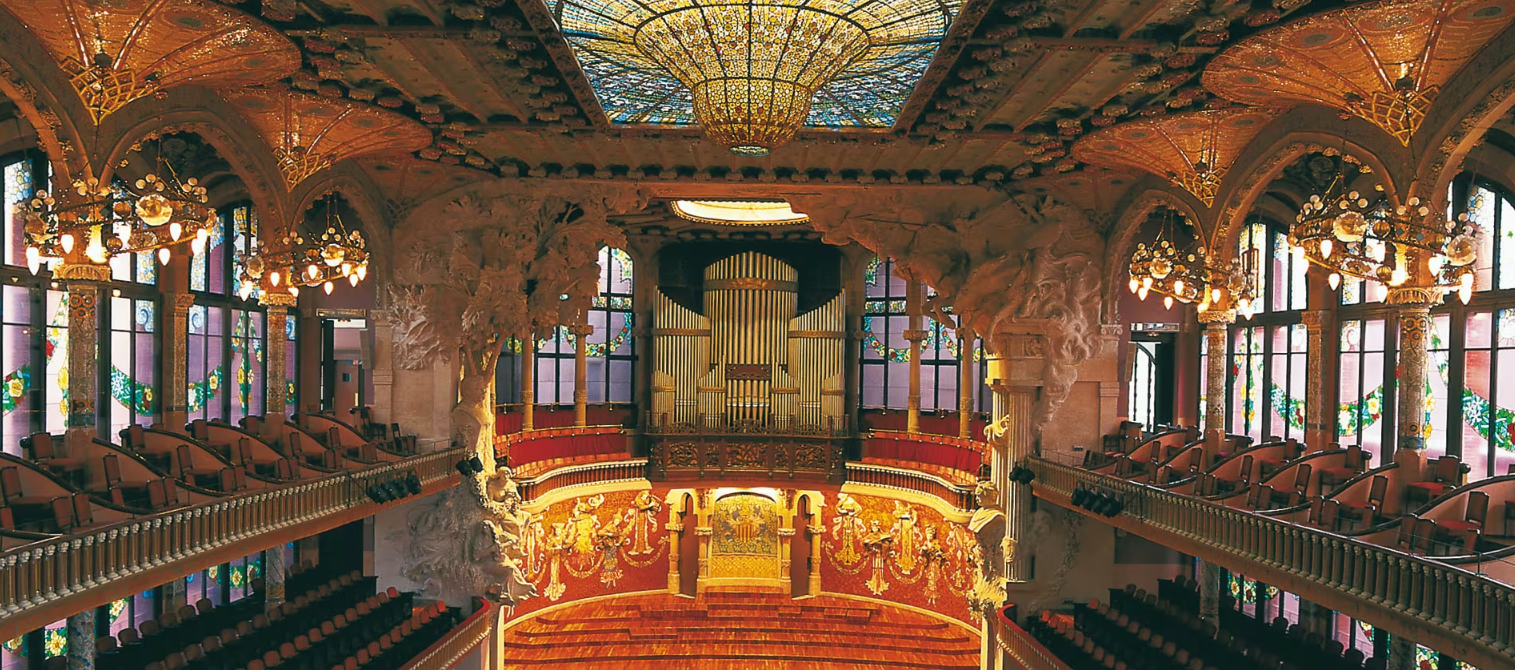 Interior do Palau de la Música Catalana em Barcelona, com vitrais coloridos e órgão monumental