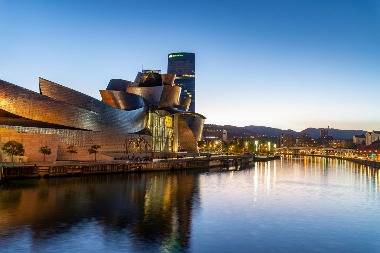 Museo Guggenheim Bilbao de Frank Gehry al atardecer, reflejado en la Ría de Bilbao - País Vasco, España