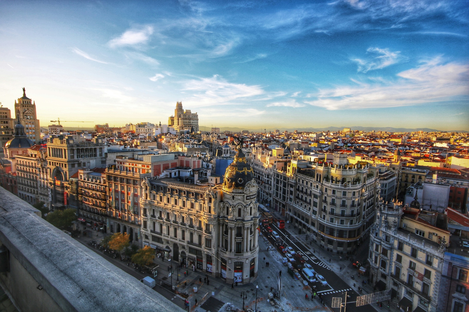 Vista panorámica de la Gran Vía de Madrid al atardecer, con el icónico Edificio Metrópolis en destaque - España