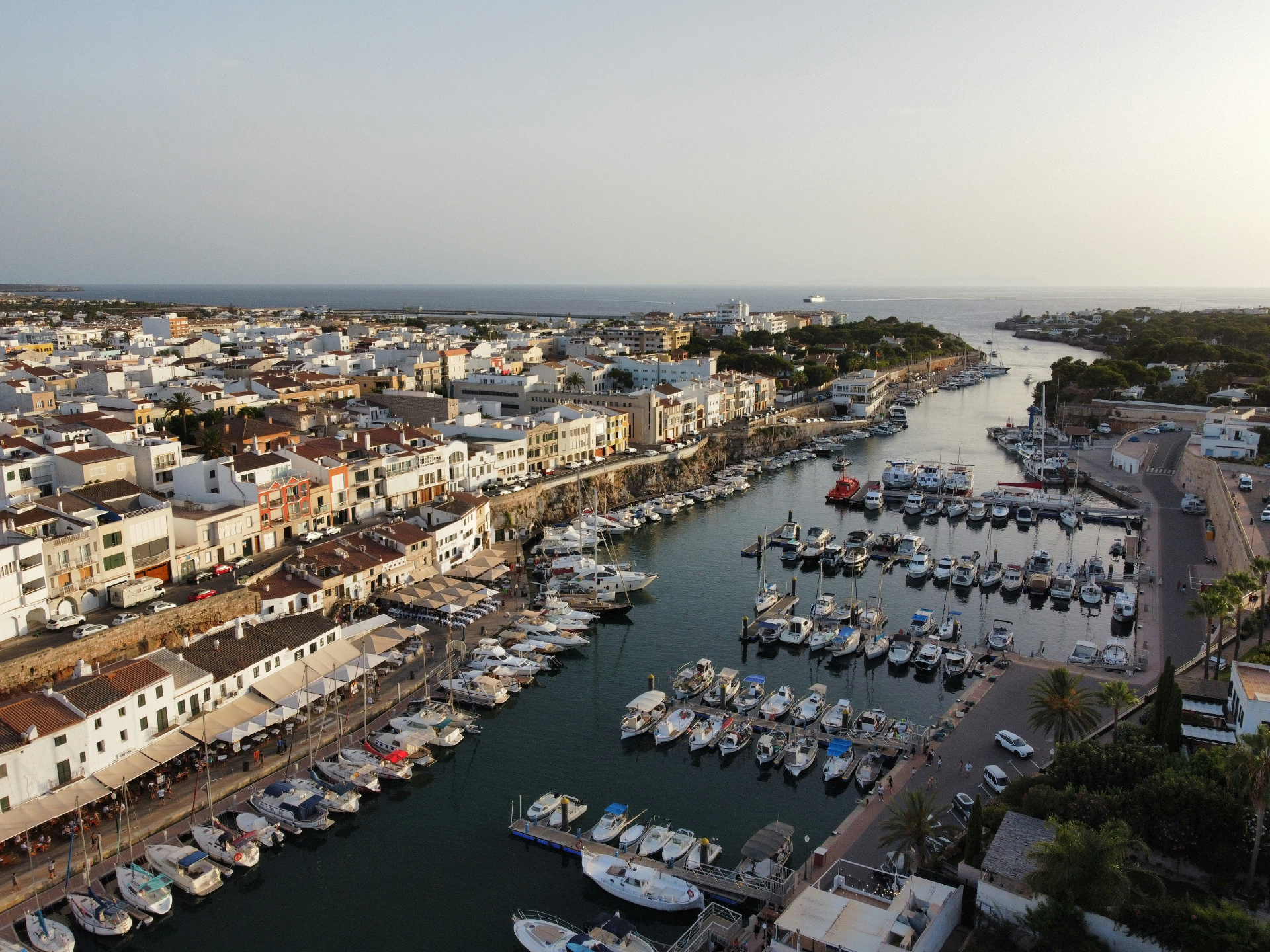 Puerto de Ciutadella en Menorca con barcos y casas blancas mediterráneas al atardecer - Islas Baleares, España