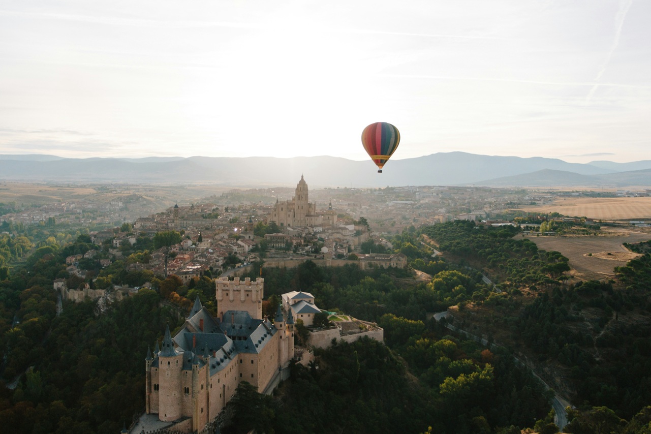 Vista aérea del Alcázar de Segovia con globo aerostático al amanecer - Castilla y León, España
