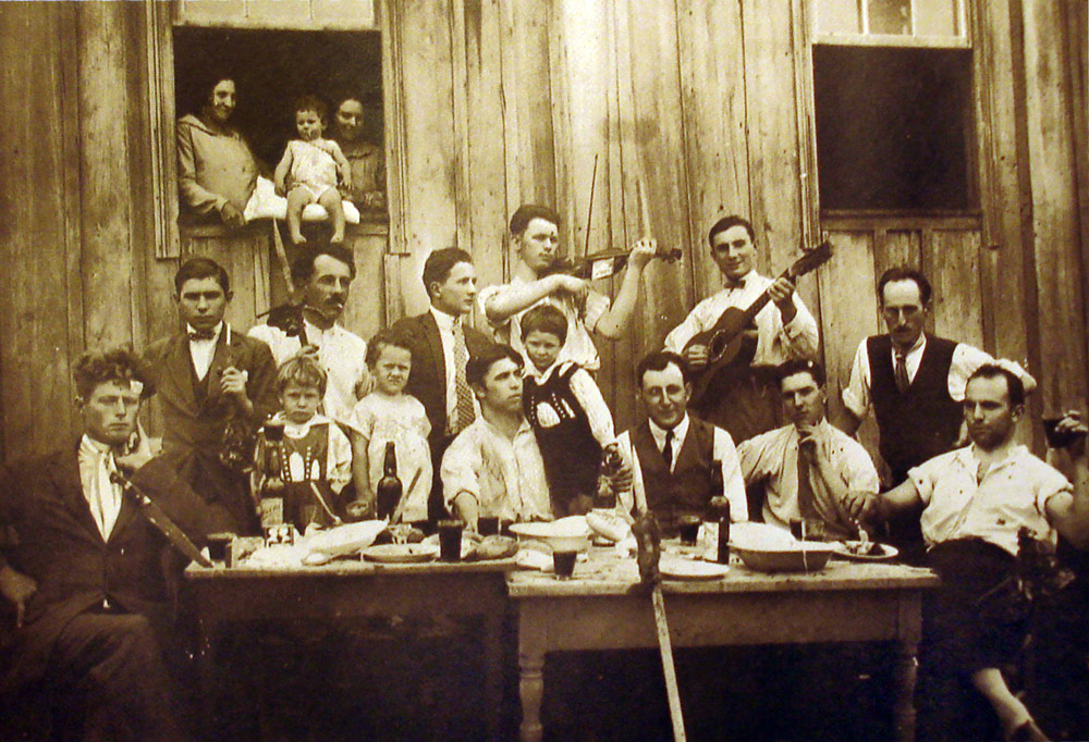 Reunião de família ítalo-brasileira em 1928 com música e violão em colônia no sul do Brasil